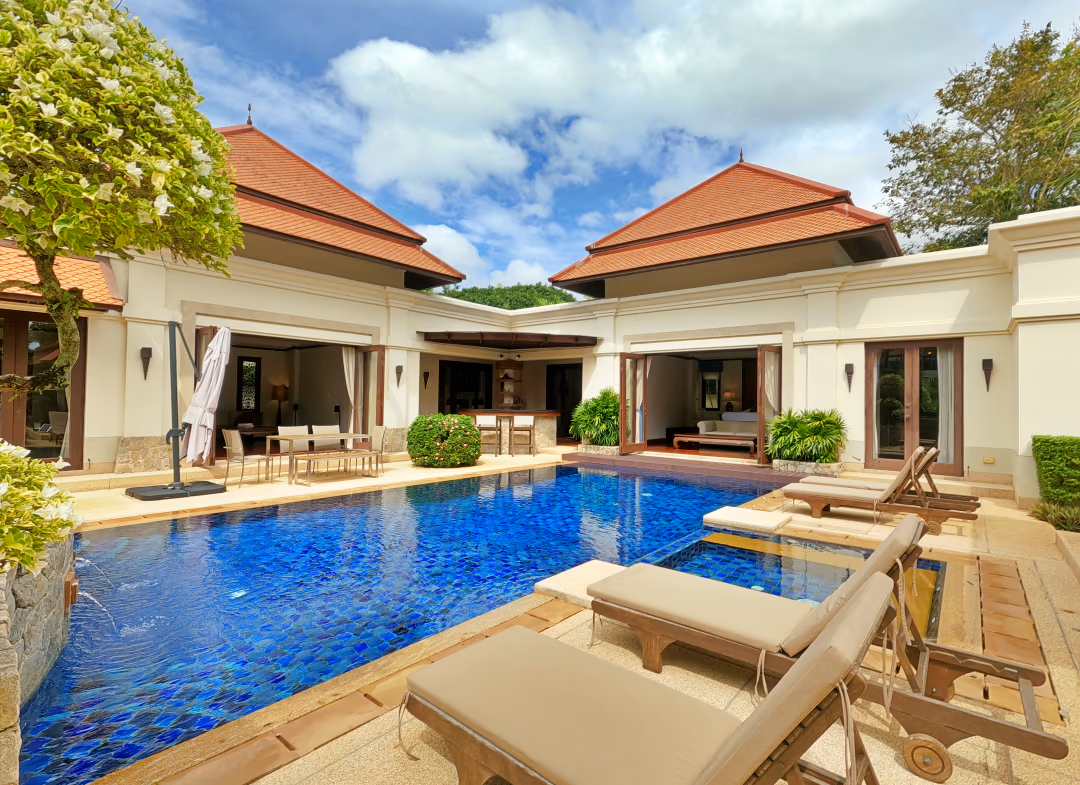 An outdoor swimming pool with a garden and patio area.