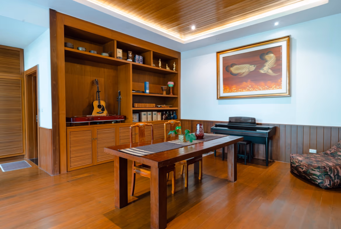 A spacious living room with large windows overlooking a tropical landscape and the ocean.