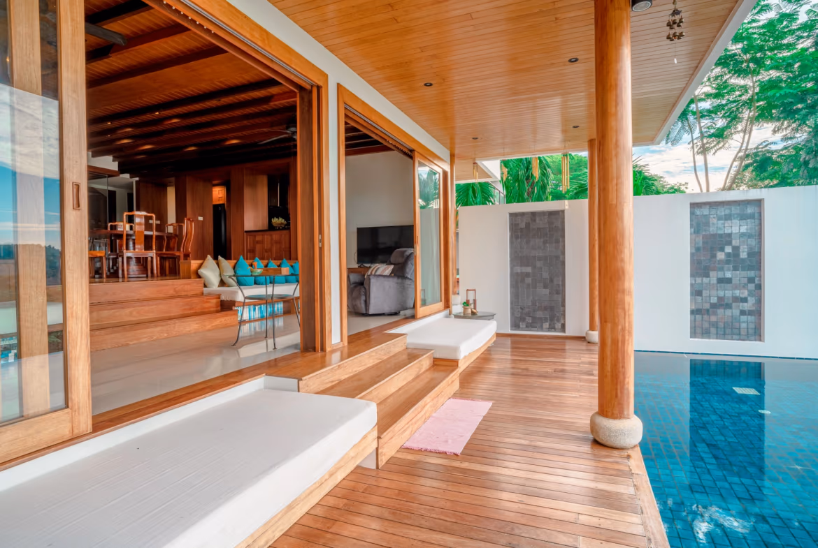 A four-bedroom villa in Surin, Thailand, featuring a traditional Thai-style design and a private swimming pool overlooking the ocean.