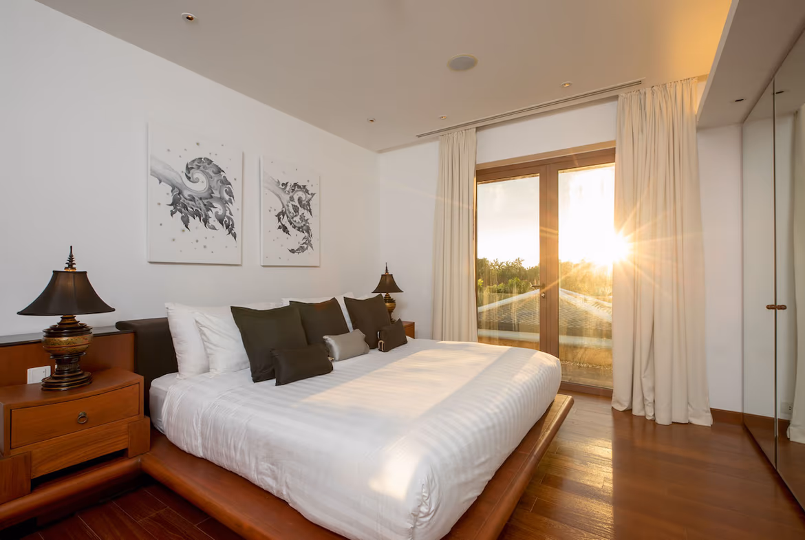 A modern, spacious living area with large glass doors opening to a private pool and ocean view.