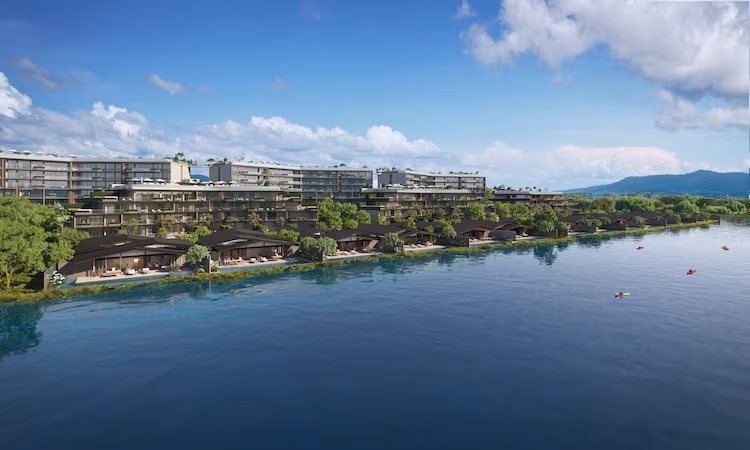 A spacious interior room with large glass doors overlooks a tranquil lake and verdant landscape.