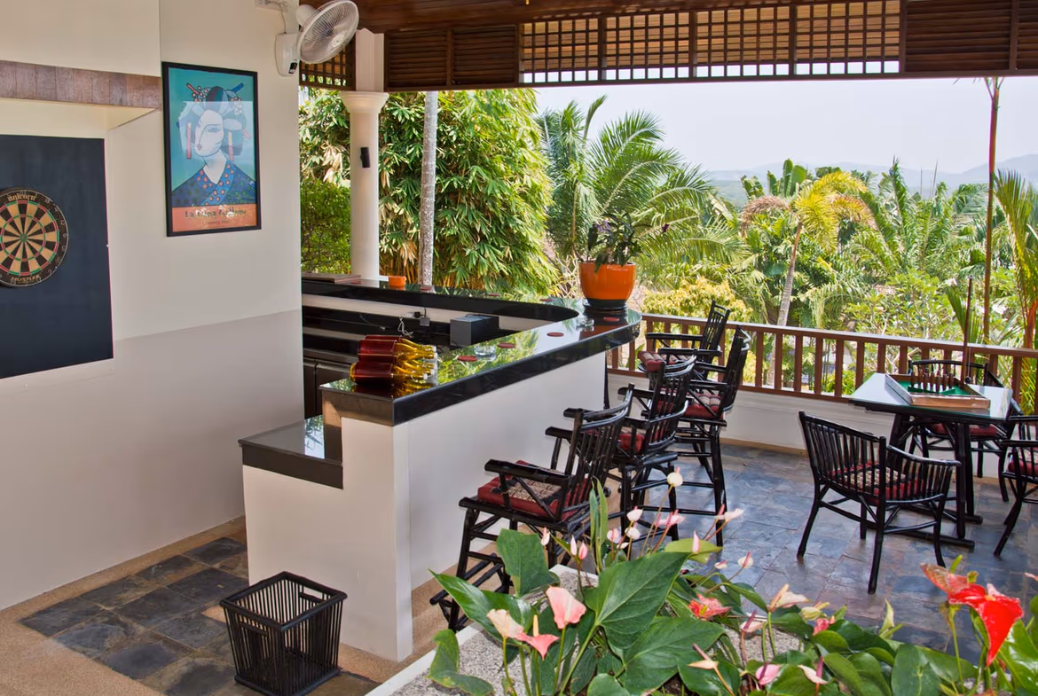 A spacious bedroom with a king-sized bed and a private balcony overlooking the pool.