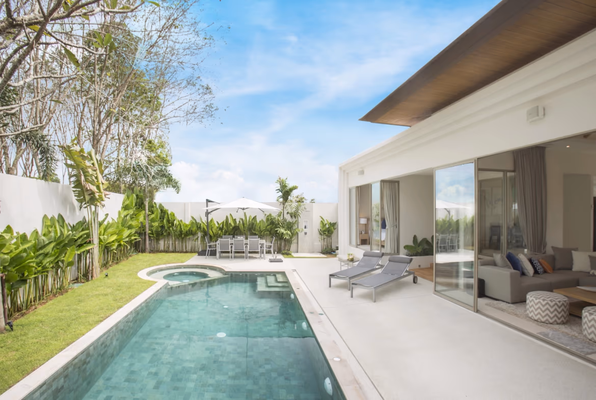 A spacious living area with modern furnishings opens onto an outdoor patio and pool.