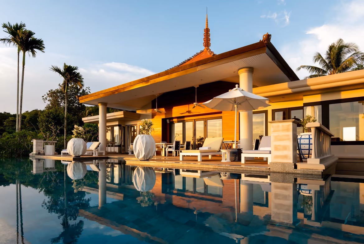 A modern infinity pool overlooks the ocean with a spacious outdoor lounging area.