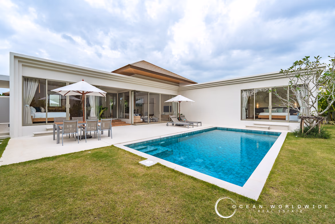 A spacious outdoor swimming pool area with lounge chairs and direct access to the modern villa.