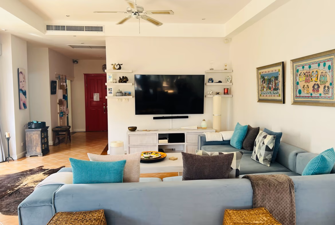 A spacious balcony overlooking a golf course and distant hills.