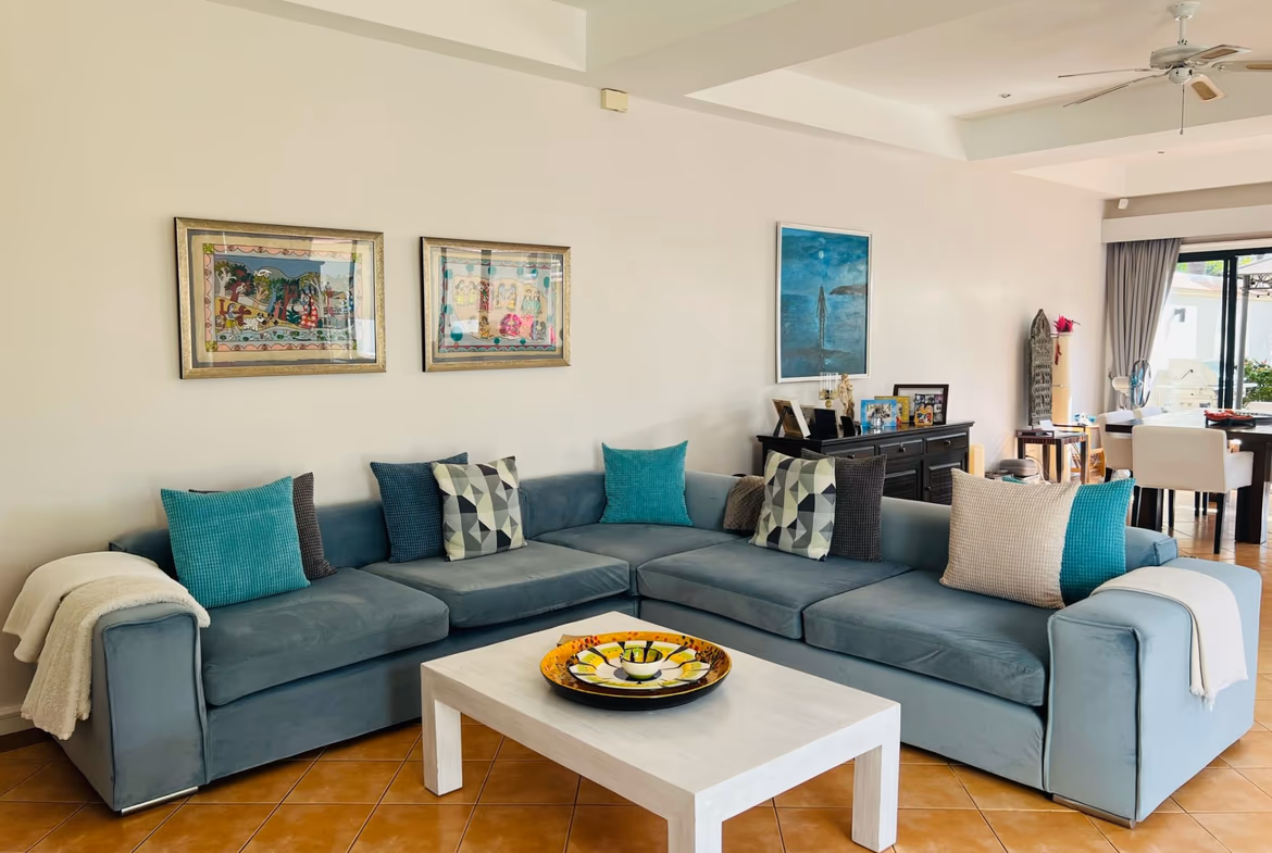A spacious living room with large windows offers a panoramic view of a golf course.