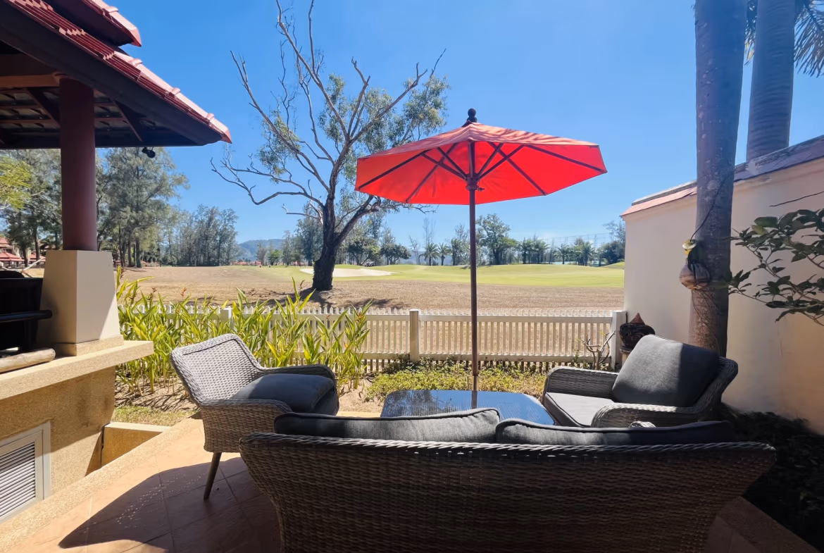A modern villa with a spacious outdoor patio overlooking a golf course.
