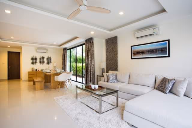 A spacious living room featuring a fireplace and large windows.