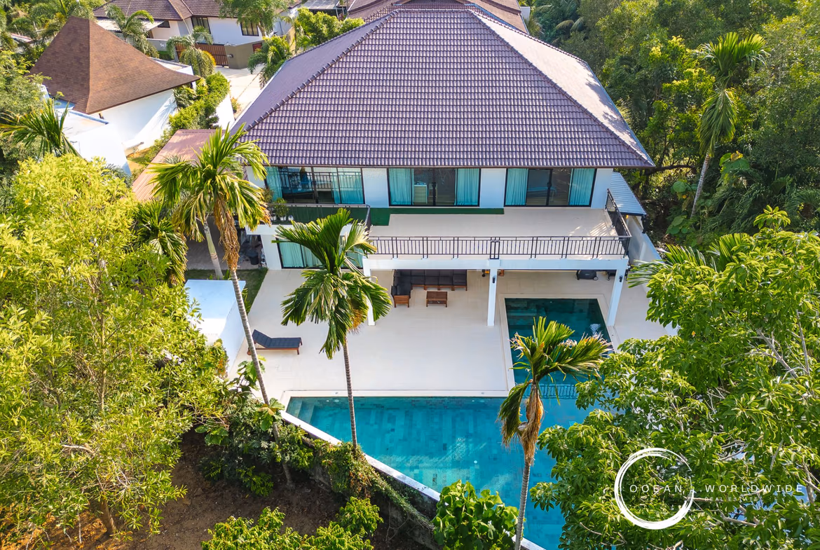 A modern bedroom with a large bed, hardwood floors, and a balcony overlooking a pool.
