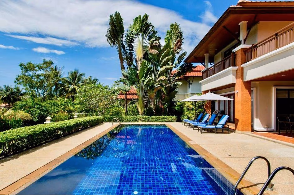 A five-bedroom villa in Bang Tao with a private pool and lake views. The modern white house has multiple balconies and a large patio surrounding the pool.