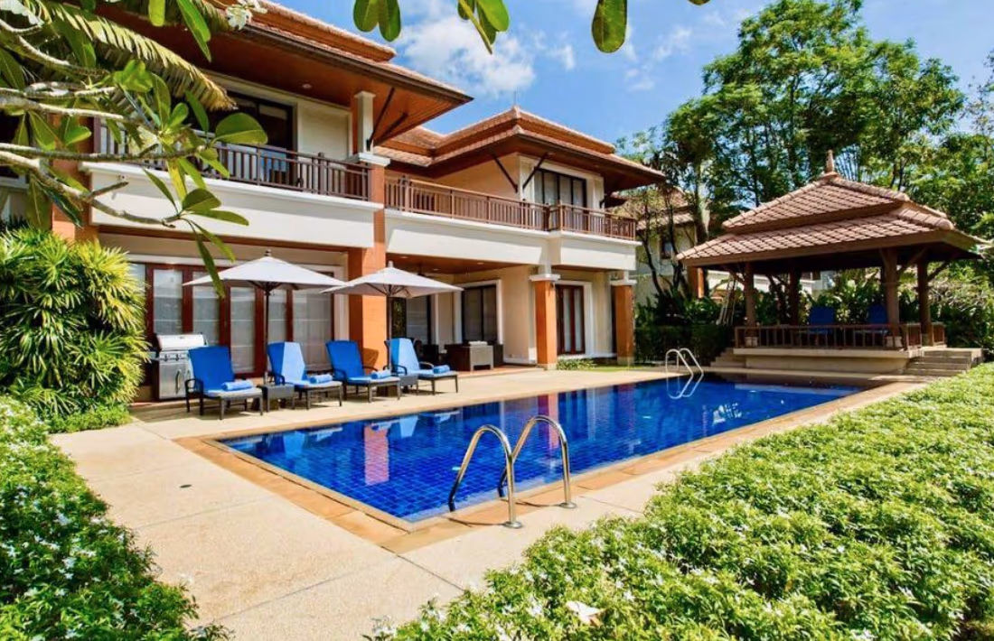 A spacious living room with large windows overlooking a lake.