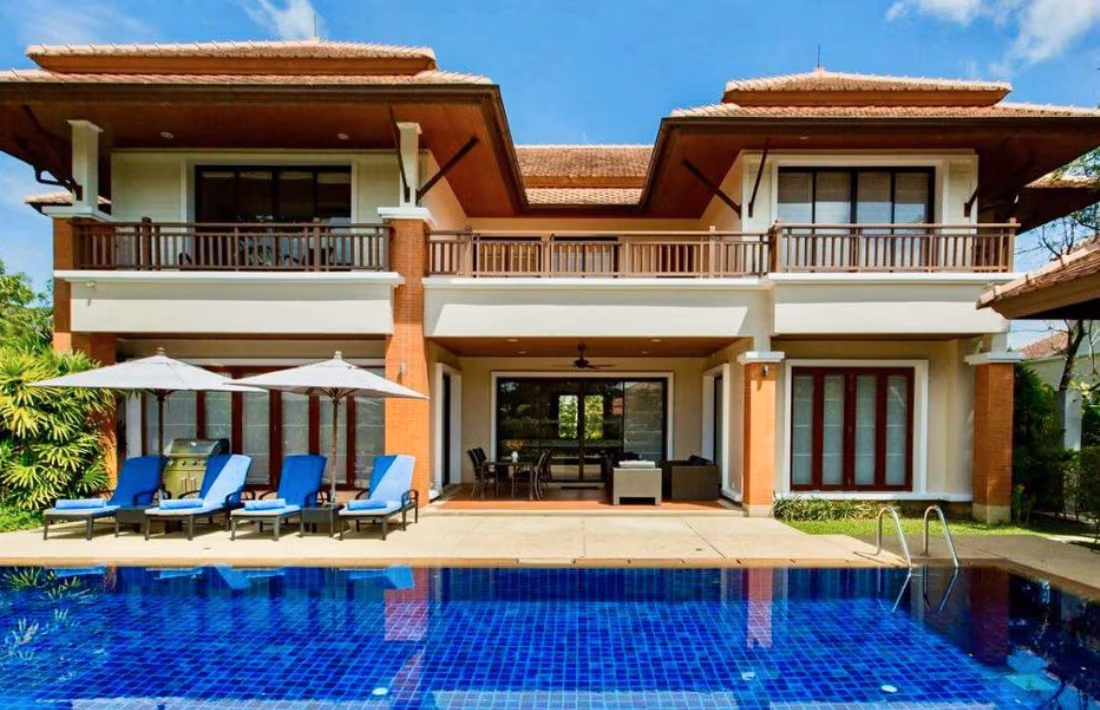 A spacious living room with large windows overlooking a lake.