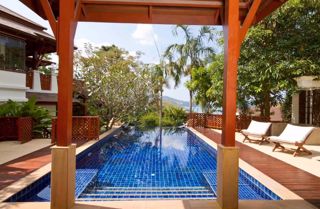 A spacious bedroom with a king-sized bed and a private balcony overlooking the ocean.