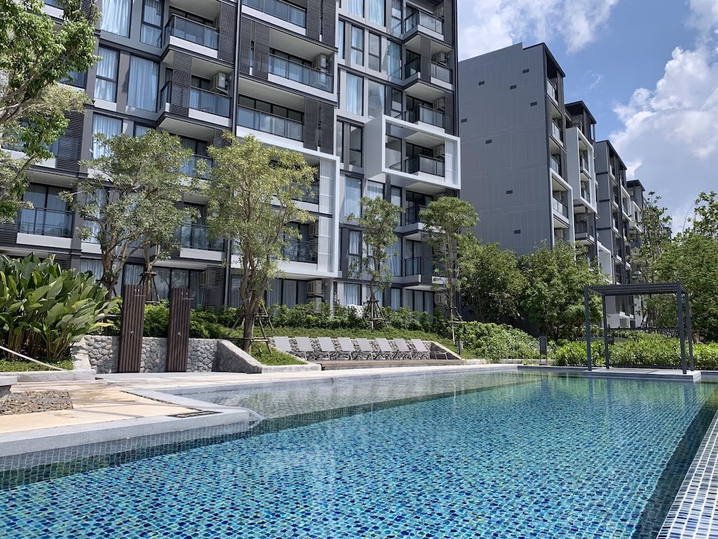 Two-bedroom condominium in Laguna near an international school. The building has a modern architectural style and overlooks a lake.
