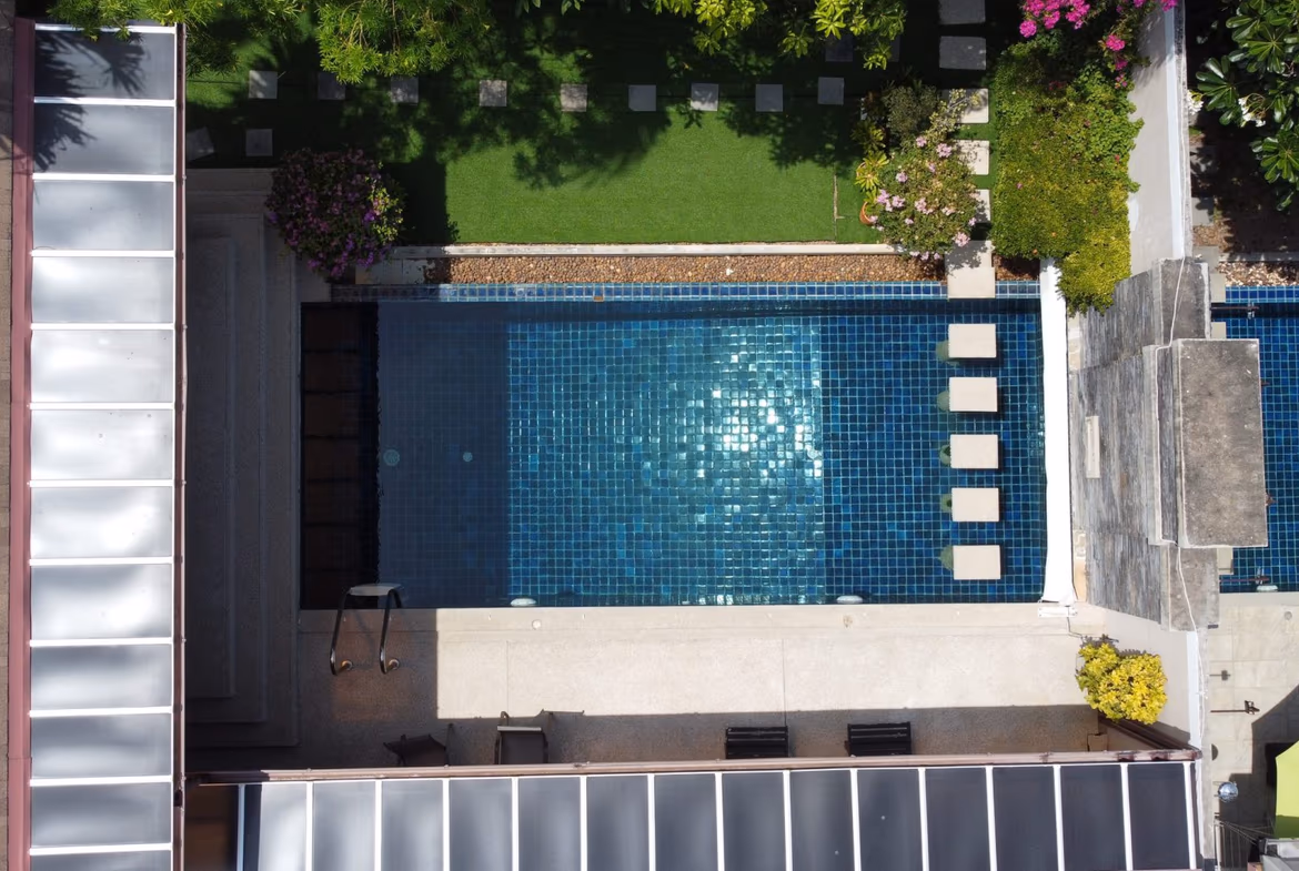 A wide shot of the living room opening to a swimming pool and outdoor patio.