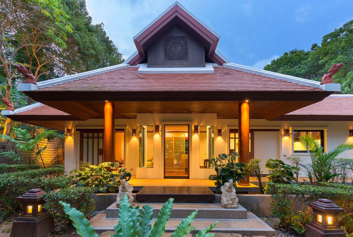 A white, contemporary four-bedroom villa in Rawai, Thailand, features a private swimming pool visible in the foreground.