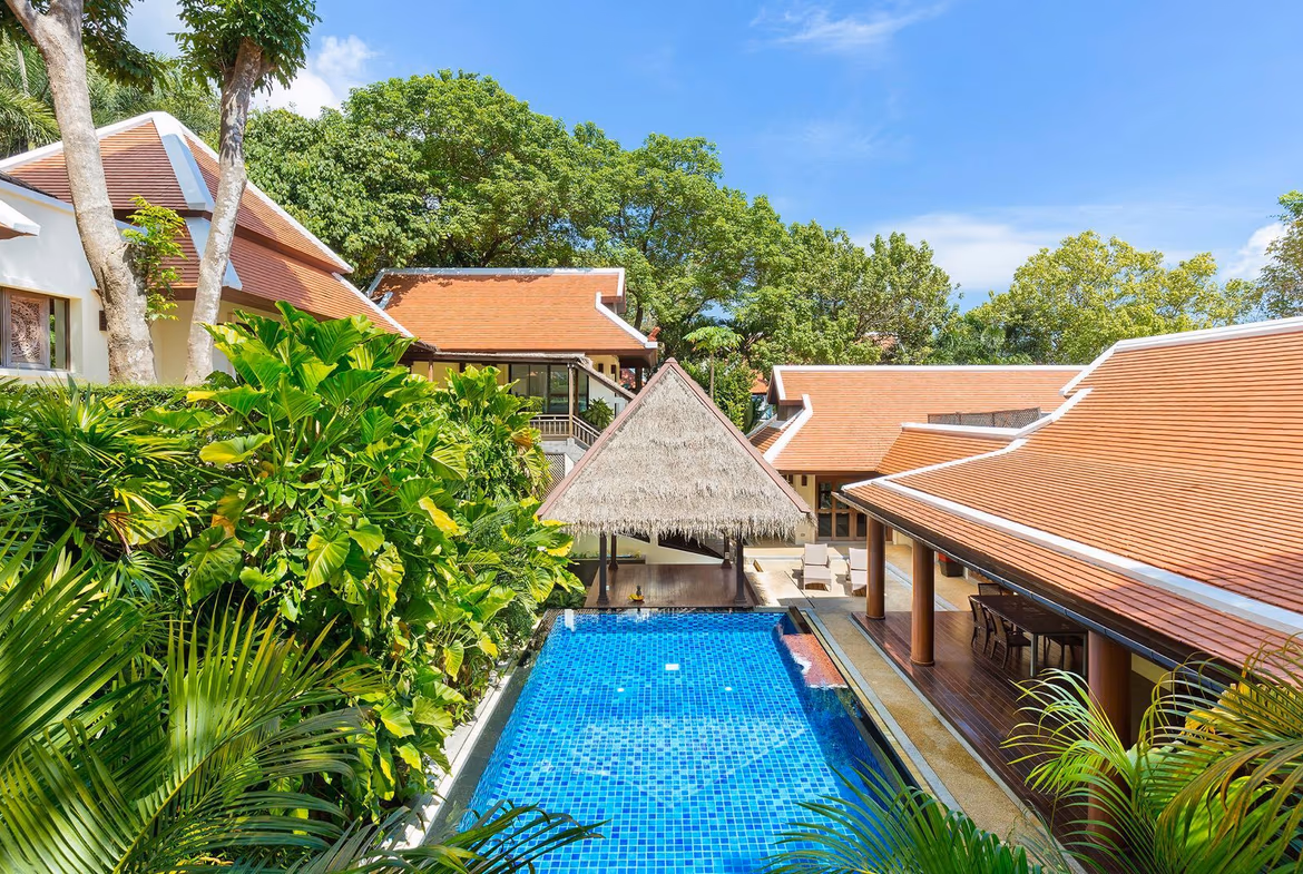 An open-concept living area with a sofa, a coffee table, and a view of the outdoor pool.
