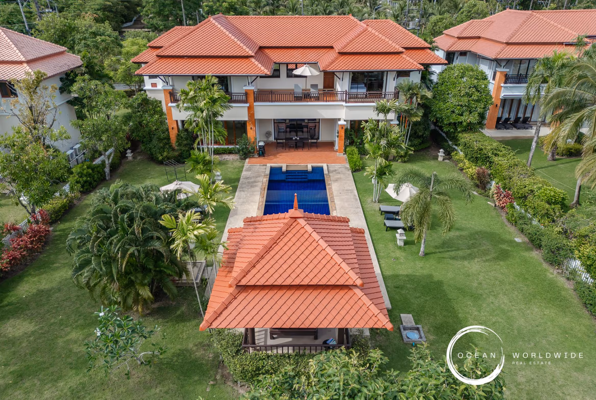 A spacious bedroom with a private balcony overlooking a lake.