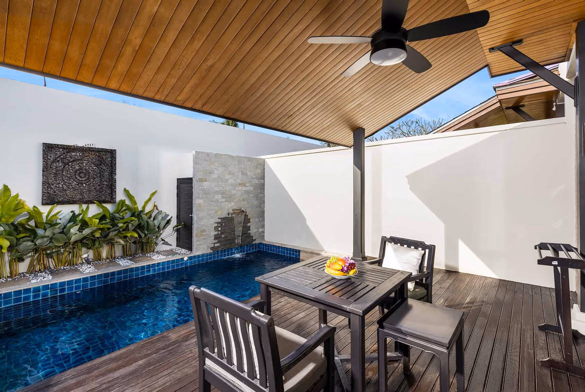 An outdoor patio with a swimming pool and sun loungers.