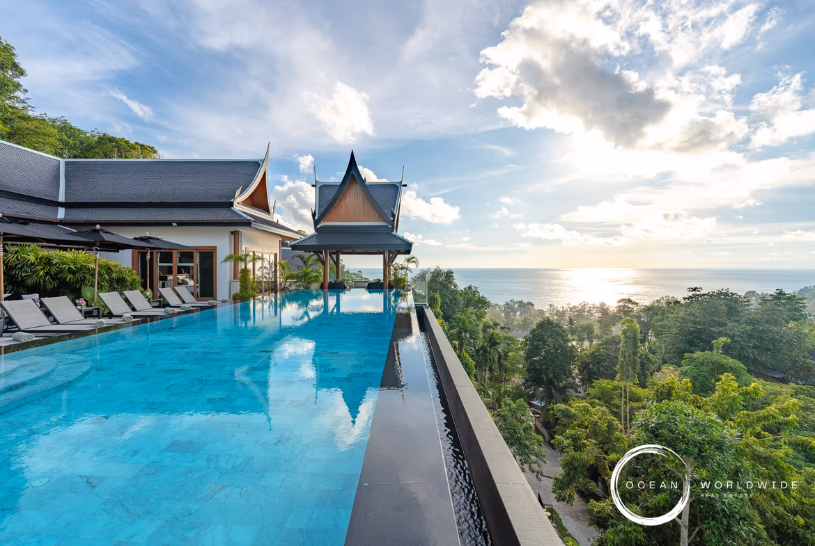 Front exterior of a 10-bedroom villa in Surin, featuring a private pool and ocean views. The property is situated on a large, landscaped plot.