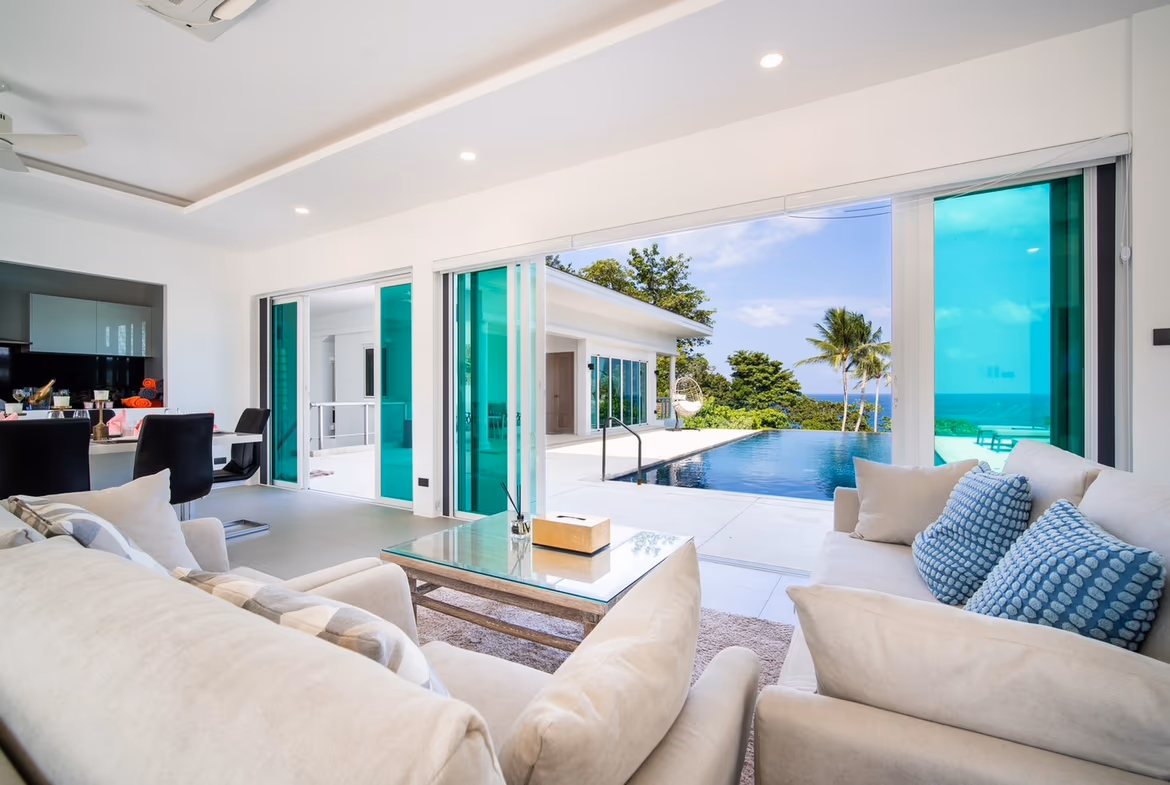 A spacious modern bedroom with a large window offering a sea view.