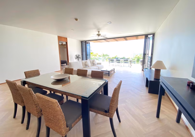 A small, modern kitchen with light wood cabinets and stainless steel appliances.
