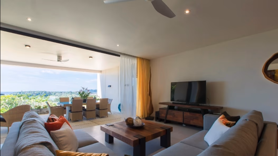 A modern bedroom with a large window likely offering a sea view.