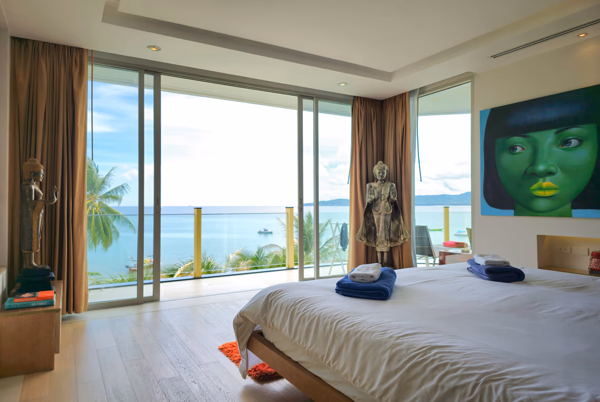 A spacious living room with modern furnishings and a view of the ocean.