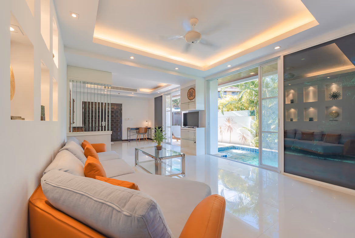 A spacious, minimally furnished room with a large window and what appears to be a bed.