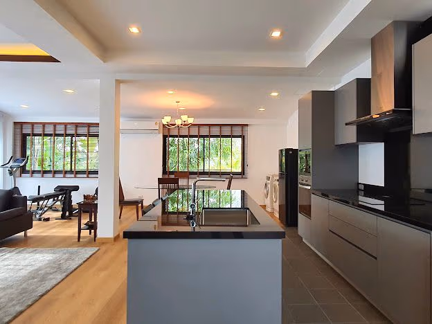 A brightly lit, modern living room with a large sofa, coffee table, and an accent wall.