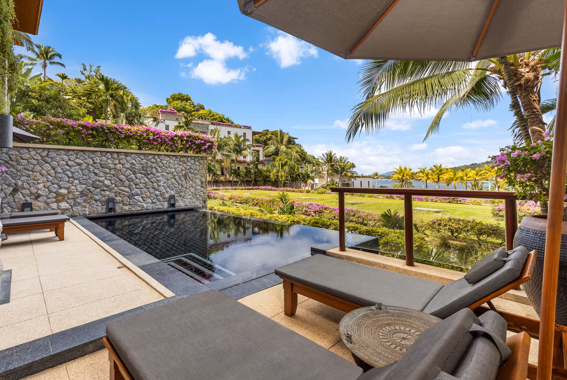 A modern kitchen with stainless steel appliances and an island overlooks the ocean.