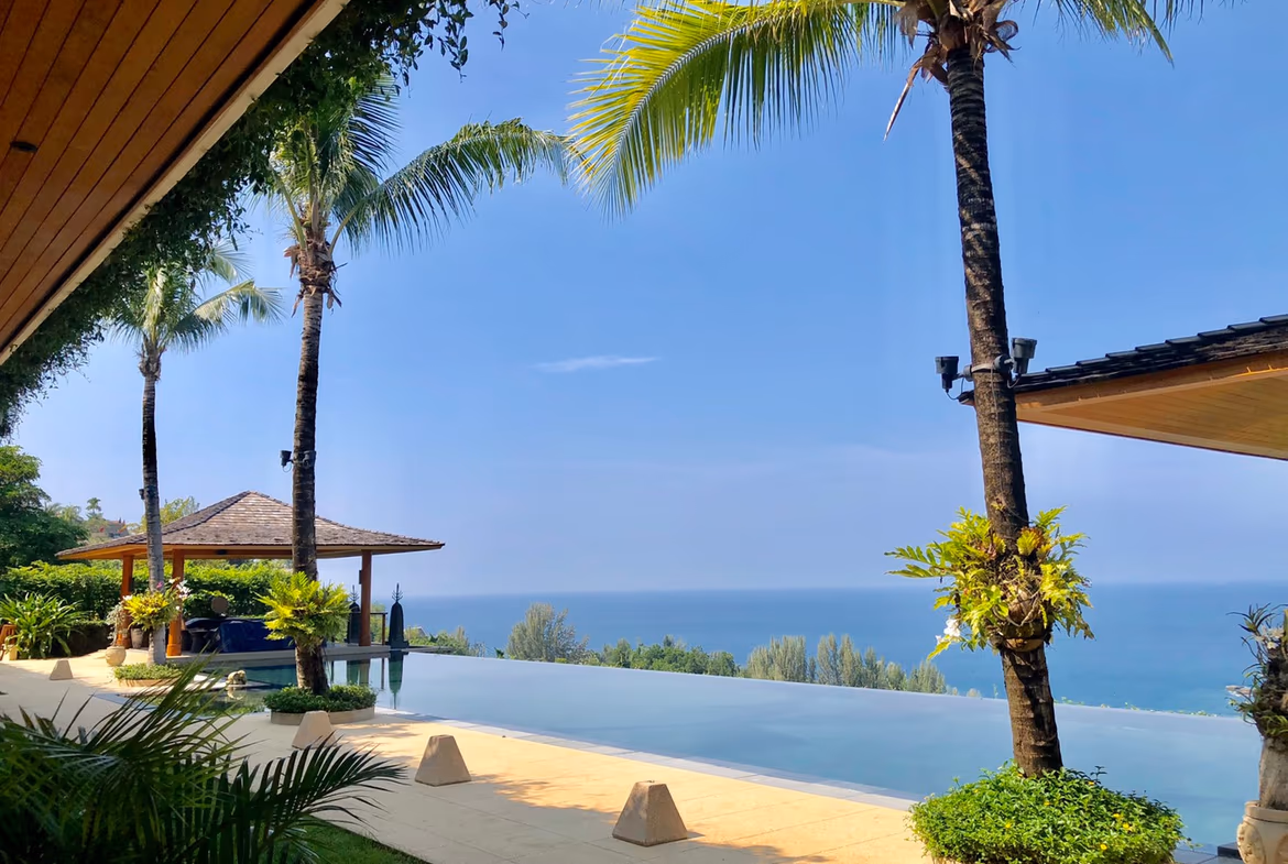 A spacious master bedroom with an attached balcony offering panoramic ocean views.