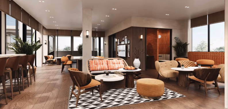 A modern kitchen area with a dark countertop and stainless steel appliances, open to a living room with a sofa.