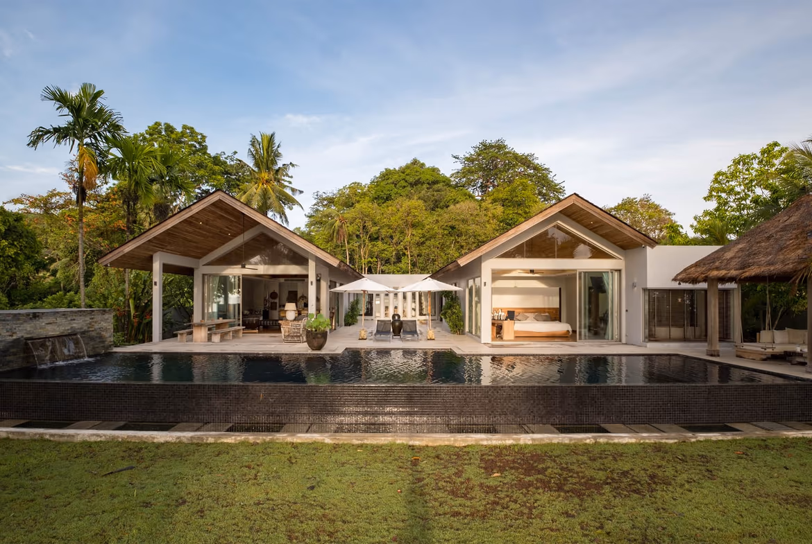 An infinity pool overlooks a tropical bay with islands in the distance.