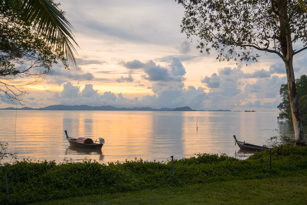 A luxurious outdoor infinity pool overlooking a tropical bay and distant mountains.