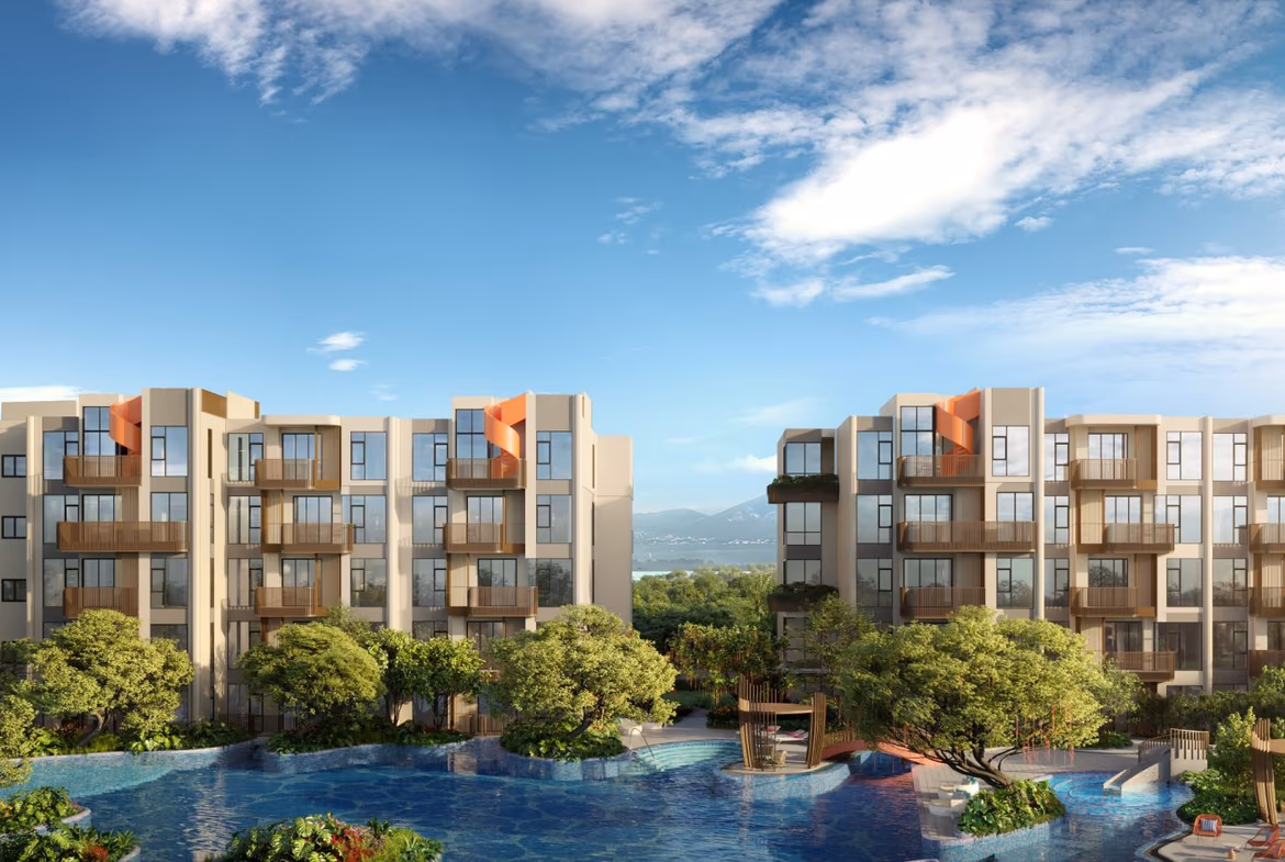 This is an exterior photo of a condominium unit in Bang Tao, within a gated community. The one-bedroom unit features a modern facade and is surrounded by tropical landscaping.