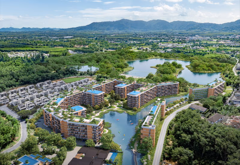 Exterior of a condominium in Phuket, featuring a multi-story building with balconies overlooking a lake.