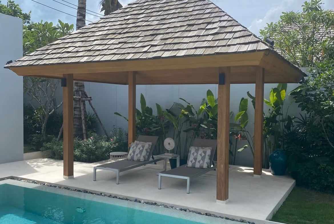 A three-bedroom villa in Phuket featuring a private pool and a traditional red tile roof.
