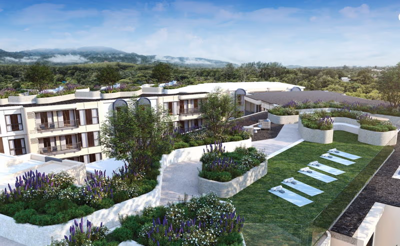 A one-bedroom condominium in Phuket with a private pool. The condo building is modern and surrounded by lush tropical landscaping.