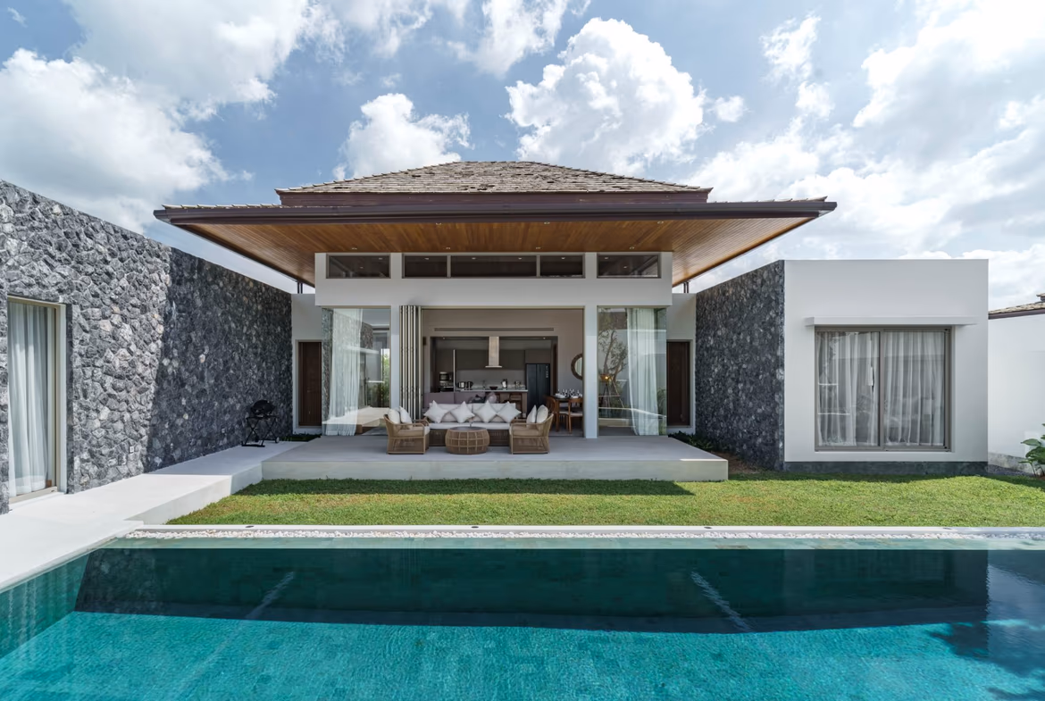 A modern, spacious living room with large windows overlooking a patio.