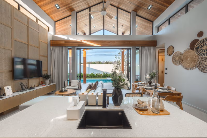 A bathroom with a large bathtub and an open view of a tropical garden.