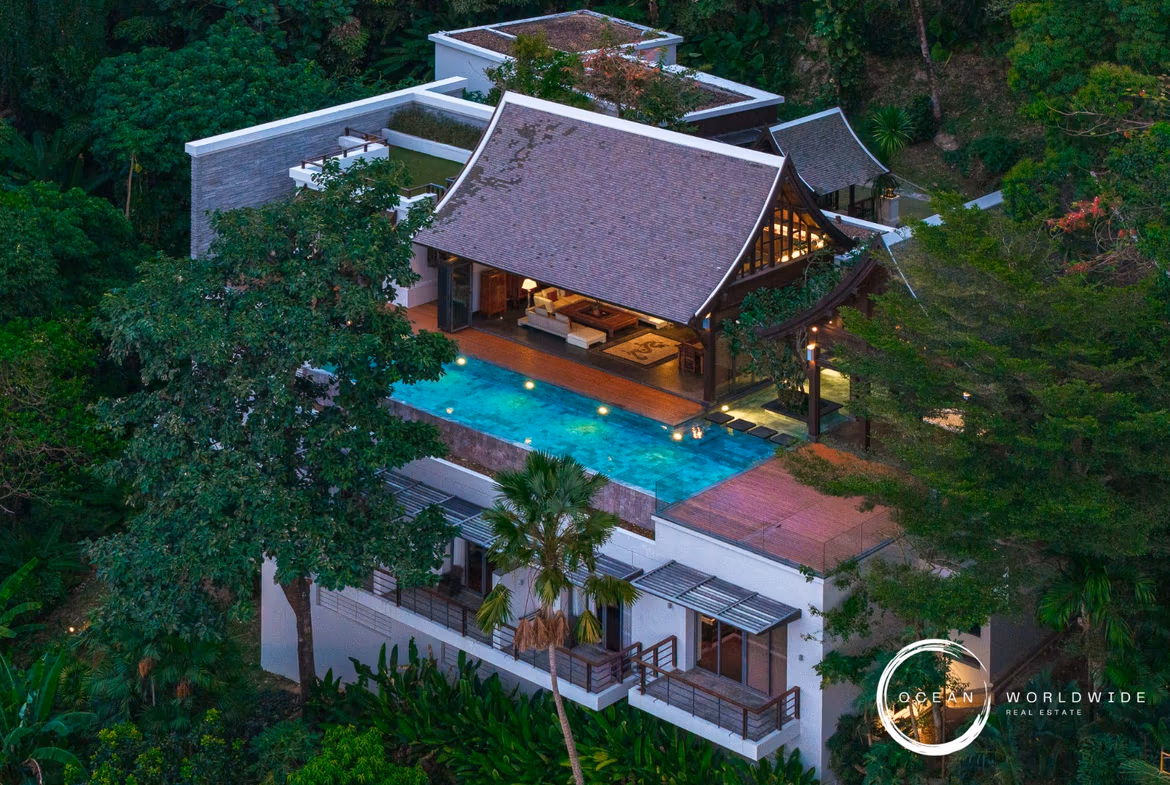 A luxurious private pool area with views of the ocean and lush tropical foliage.