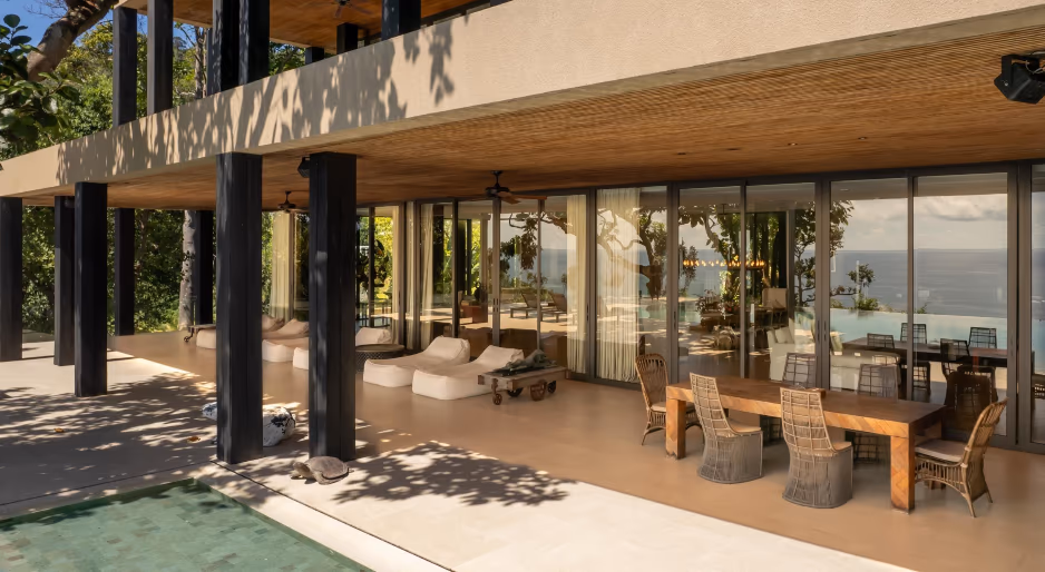 A balcony overlooks a sandy beach and the ocean.
