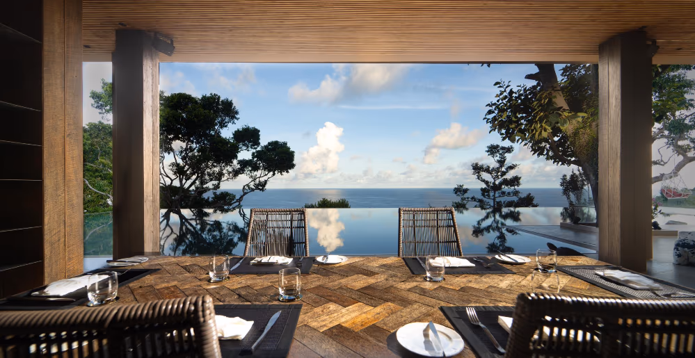 A spacious living area with modern furnishings and large windows showcasing an ocean view.