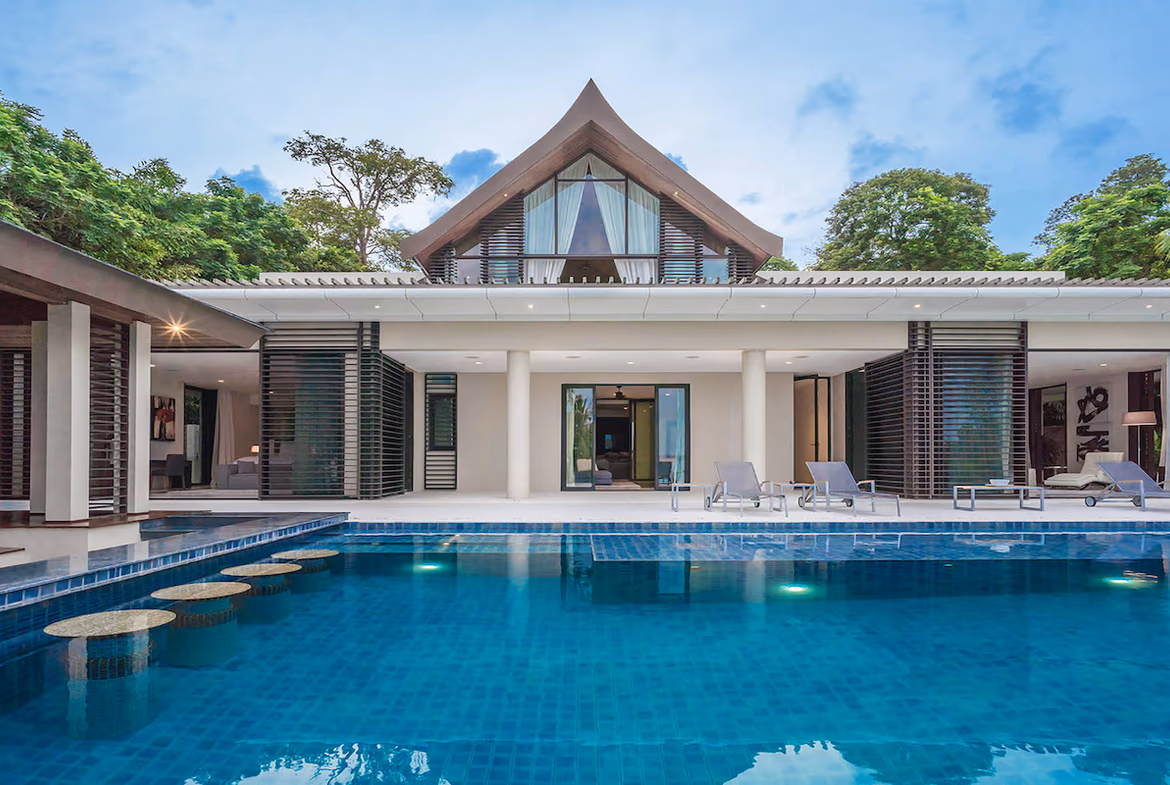 An outdoor swimming pool with a partial view of the ocean.