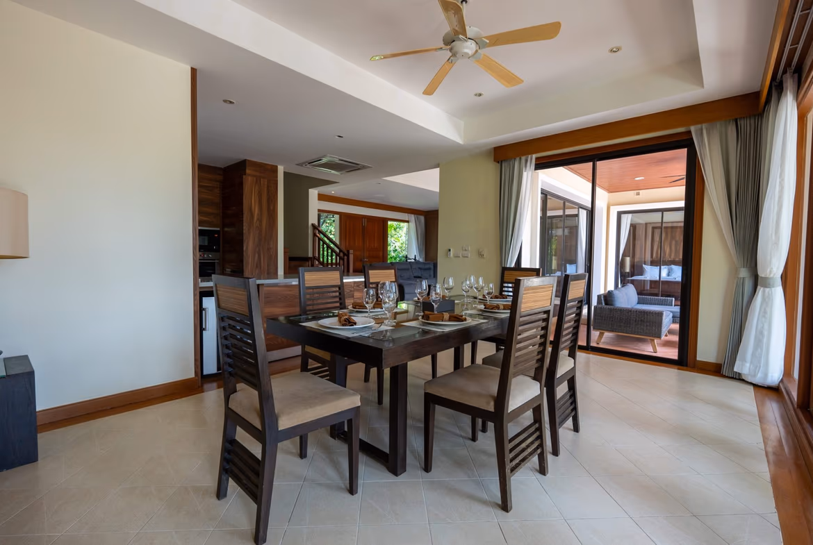 A spacious living room with large windows overlooking a patio and garden.
