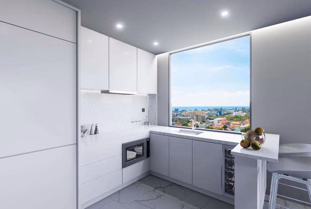 A modern living room with a large window offreing a partial view of the sea and surrounding mountains.