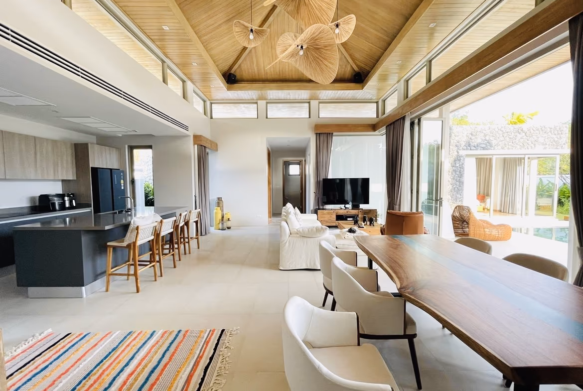 A spacious living room with modern furnishings and a view of the private pool.