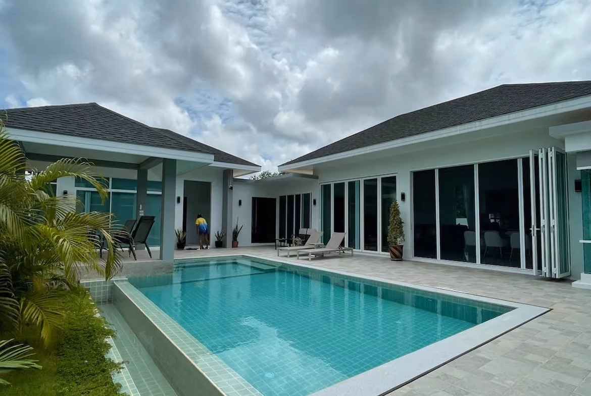 A spacious outdoor patio with a swimming pool and sun loungers.